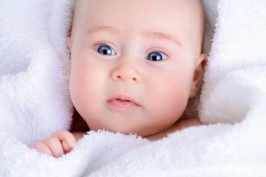 Tatlı bebek banyo sonra beyaz bir havlu. Sağlık, pediatri.
