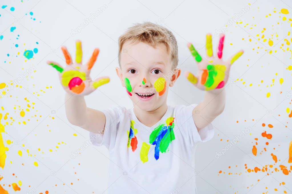 A portrait of a cute boy in colorful paints. Childhood, leisure activities.