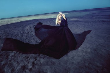 Tam uzunlukta portre güzel bir Gotik kadının uzun siyah elbise poz açık. Güzellik, moda.