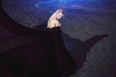 Tam uzunlukta portre güzel bir Gotik kadının uzun siyah elbise poz açık. Güzellik, moda.