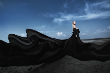 Tam uzunlukta portre güzel bir Gotik kadının uzun siyah elbise poz açık. Güzellik, moda.