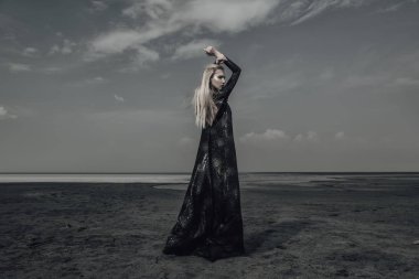 Tam uzunlukta portre güzel bir Gotik kadının uzun siyah elbise poz açık. Güzellik, moda.