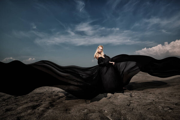 Full length portrait of a beautiful gothic woman in long black dress posing outdoor. Beauty, fashion.