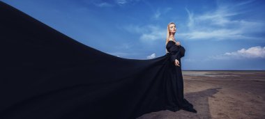 Tam uzunlukta portre güzel bir Gotik kadının uzun siyah elbise poz açık. Güzellik, moda.