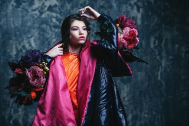 Vogue bir kadın model stüdyoda poz bir kadeh. Moda koleksiyonu. Portre grunge arka plan üzerinde.