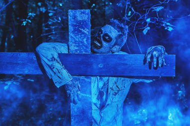 mezarda haç kucaklayan ölü kişi