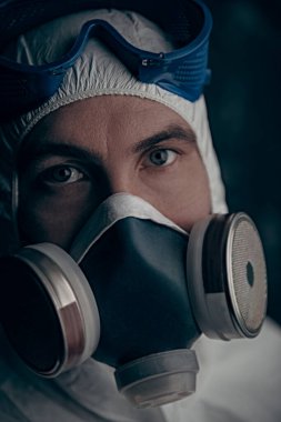 COVID-19 veya 2019-NCoV. Solunum maskesi takmış bir bilim adamının yakın plan portresi. Salgın.