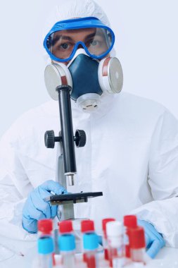 COVID-19. Doktor, mikrobiyolog, koruyucu kıyafetli bilim adamı, laboratuvarda koronavirüs üzerine bir çalışma yapıyor. Coronavirus testi.