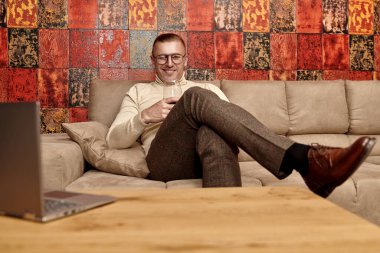 Saygıdeğer orta yaşlı bir adamın portresi günlük kıyafetler ve gözlüklerle lüks bir dairede kırmızı şarap içen. Başarı ve zengin yaşam tarzı.