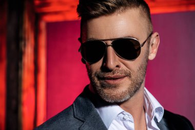 Güneş gözlüklü yakışıklı bir adamın yakın plan portresi. Erkek güzelliği, moda. Erkekler için optik.