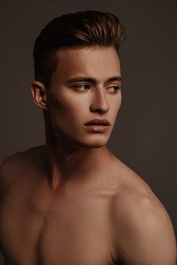 Siyah arka planda yakışıklı, kaslı bir adamın portresi. İnsanın güzelliği ve sağlığı. Spor konsepti.
