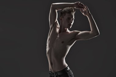 Mükemmel kaslı vücudu olan yakışıklı bir genç adamın portresi. Spor ve vücut geliştirme. Erkek güzelliği ve sağlığı. Boşluğu kopyala.