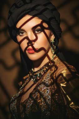 Doğulu peri masalı. Geleneksel makyaj ve siyah tesettüre sahip güzel bir Arap kadının portresi. Makyaj ve kozmetik. 
