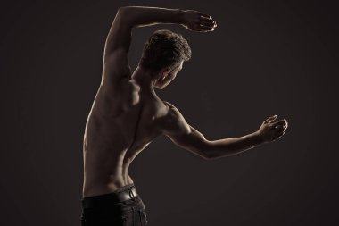 Mükemmel kaslı vücudu olan yakışıklı, atletik bir gencin portresi. Spor ve vücut geliştirme. Erkek güzelliği ve sağlığı. Boşluğu kopyala.