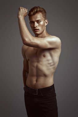 Mükemmel kaslı vücudu olan yakışıklı bir genç adamın portresi. Spor ve vücut geliştirme. Erkeklerin güzelliği ve sağlığı.