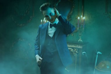 Zarif bir klasik takım elbise içinde yakışıklı bir adamın portresi ve klasik bir iç mekânda papyon. İş stili. Erkek modası.