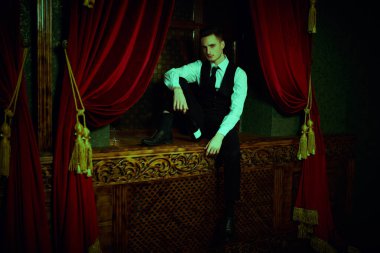 Zarif klasik takım elbiseli yakışıklı bir adamın portresi lüks bir apartmanda oturuyor. Erkek modası.