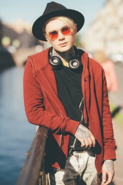 Sokakta yürüyen, açık saçlı genç bir adamın portresi. Güzellik, optik, gündelik moda.