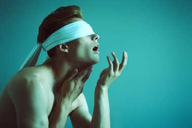 Mükemmel kaslı vücudu olan yakışıklı bir adamın sanat portresi. Acı çektiğini gösteriyor. Boşluğu kopyala. 