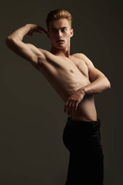 Mükemmel kaslı vücudu olan yakışıklı bir genç adamın portresi. Spor ve vücut geliştirme. Erkeklerin güzelliği ve sağlığı. 