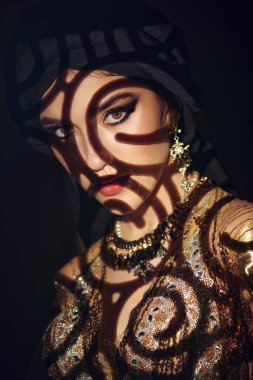 Doğulu peri masalı. Geleneksel makyaj ve siyah tesettüre sahip güzel bir Arap kadının portresi. Makyaj ve kozmetik. 