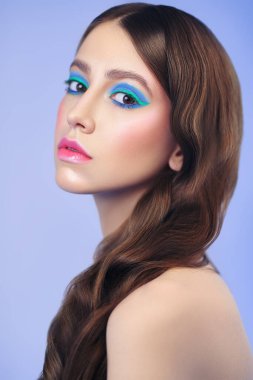 Makyaj ve makyaj malzemeleri. Leylak arka planında canlı renkli makyajlı güzel bir kızın yakın plan portresi..