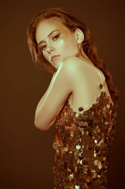 Makyaj ve makyaj malzemeleri. Koyu gri arka planda altın makyajlı muhteşem bir genç kadının portresi. Parti biçimi.