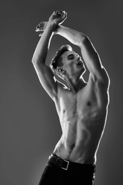 Mükemmel kaslı vücudu olan yakışıklı bir genç adamın siyah-beyaz portresi. Spor ve vücut geliştirme. Erkeklerin güzelliği ve sağlığı.