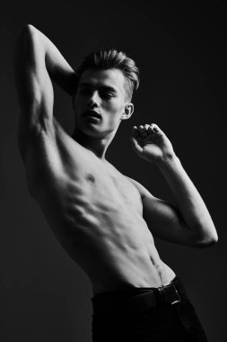 Mükemmel kaslı vücudu olan yakışıklı bir genç adamın siyah-beyaz portresi. Spor ve vücut geliştirme. Erkeklerin güzelliği ve sağlığı.