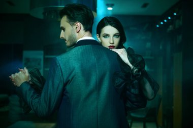 Birbirlerine aşık güzel bir çift tutkuyla tango yapıyor. Akşam makyajı ve saç stili. Şık kıyafetler..