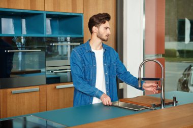 Evdeki mutfakta mutlu genç bir adam. Evin içi, mobilyalar.. 