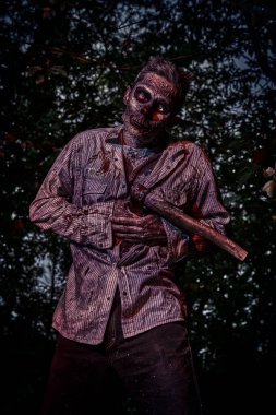 Gece ormanında elinde balta olan korkunç kanlı zombi. Cadılar Bayramı. Heyecan.