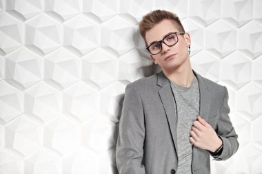 Takım elbiseli ve gözlüklü zeki bir gencin portresi. Stüdyo çekimi. Erkeklerin güzelliği.