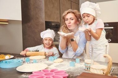 Mutlu anne ve kızları evdeki mutfakta yemek yaparak para kazanıyorlar. Mutlu bir aile. Evde sağlıklı yiyecekler..