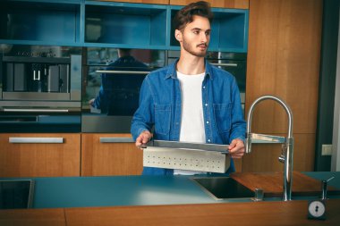 Evdeki mutfakta mutlu genç bir adam. Evin içi, mobilyalar.. 