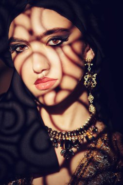 Doğulu peri masalı. Geleneksel makyaj ve siyah tesettüre sahip güzel bir Arap kadının portresi. Makyaj ve kozmetik. 