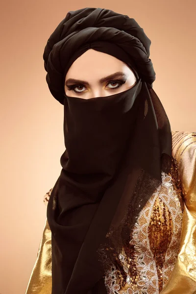 Oriental beauty woman. Portrait of a beautiful arabian woman in traditional look, with traditional oriental make-up and black hijab. Make-up and cosmetics.