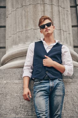 Sokakta poz veren yakışıklı bir genç. Yaz modası. Yaz tatili ve tatil.