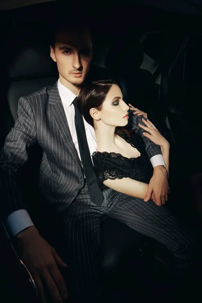 Glamorous passionate couple in a car. Beauty, fashion.