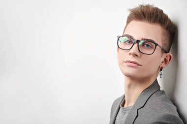Takım elbiseli ve gözlüklü zeki bir gencin portresi. Stüdyo çekimi. Erkeklerin güzelliği.