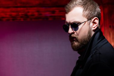 Güneş gözlüğü takan şık bir adamın yakın plan portresi. Erkekler için güzellik ve tarz.