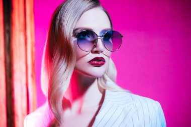 Güneş gözlüğü takan kendine güvenen bir kadının yakın portresi. Güzellik, makyaj, tarz.