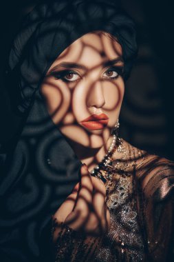 Doğulu peri masalı. Geleneksel makyaj ve siyah tesettüre sahip güzel bir Arap kadının portresi. Makyaj ve kozmetik. 