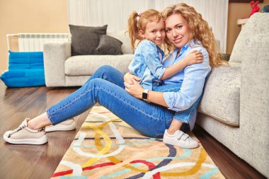 Evde mutlu bir aile hayatı. Bir anne, sevimli kızıyla oturma odasında oynayarak vakit geçirir..