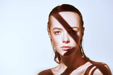 Güzellik konsepti. Taze doğal makyajlı ve mükemmel sağlıklı ciltli güzel bir genç kadının portresi. Işık ve gölge oyunu. Moda. Boşluğu kopyala.