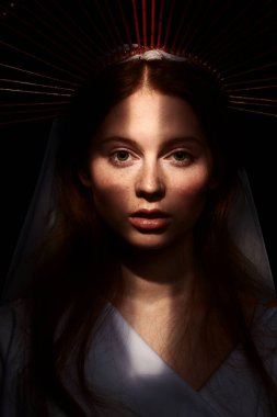 Karanlık bir arka planda ışık ışınlarıyla Bakire Meryem portresi. Modern din sanatı. Vaftiz töreni..