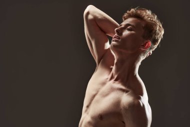 Mükemmel kaslı vücudu olan yakışıklı bir genç adamın portresi. Spor ve vücut geliştirme. Erkeklerin güzelliği ve sağlığı.