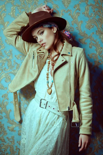 Modern bohemian style. Portrait of a beautiful young woman with elegant natural make-up, beads and clothes in boho style.