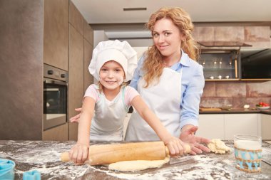 Mutlu anne ve kızı evdeki mutfakta yemek yaparak para kazanıyorlar. Mutlu bir aile. Evde sağlıklı yiyecekler..
