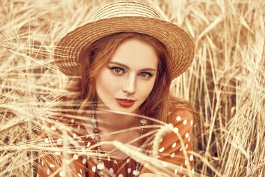 Buğday tarlasında oturan romantik hippi kız. Yaz. Hippi, bohem tarzı.